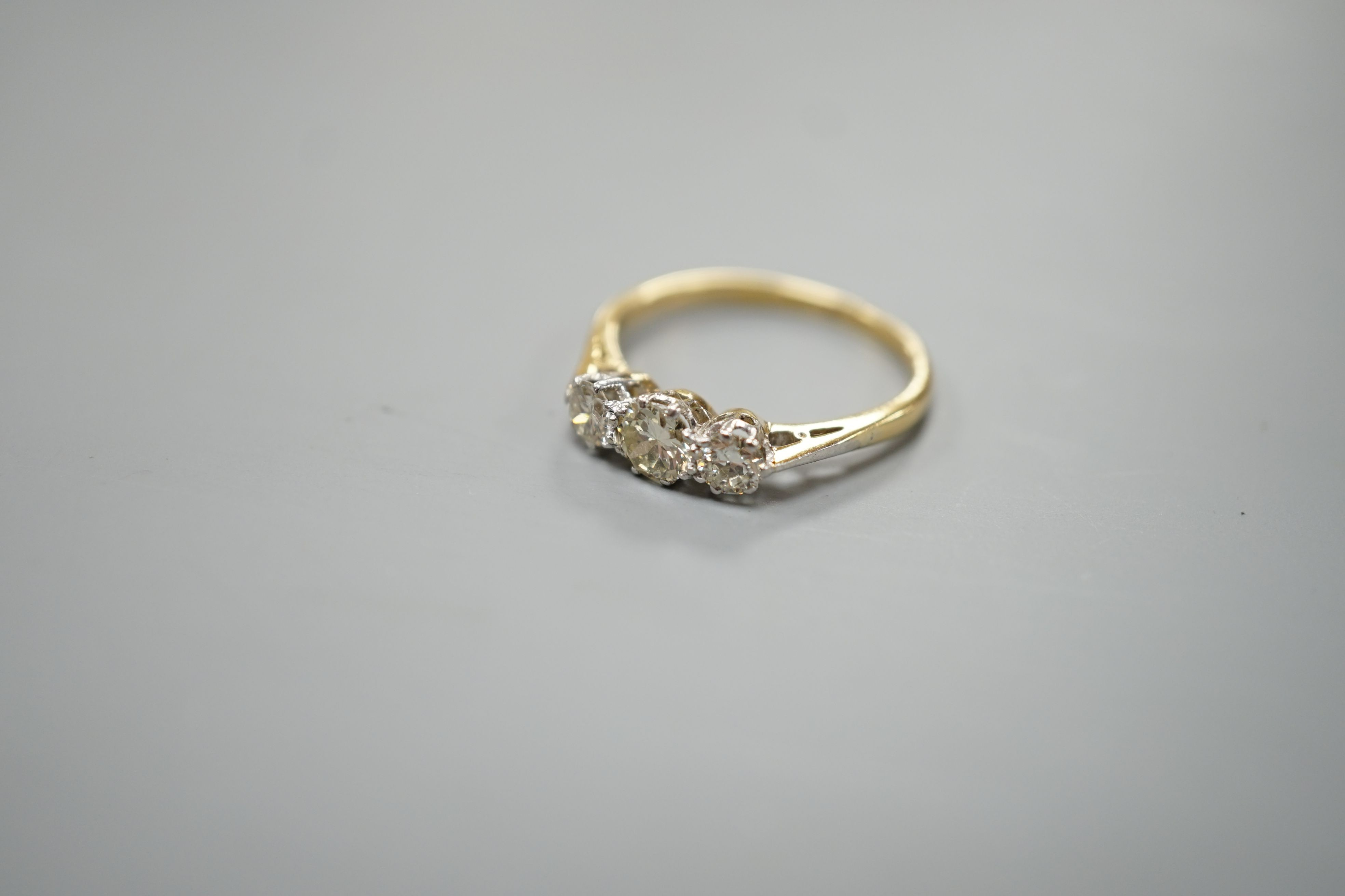 An 18ct gold and platinum three stone diamond ring, size M, gross 2.4 grams.